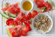 Wassermelonen-Tomaten-Salat auf einem weissen Serviertablett Wassermelonen-Tomaten-Salat auf einem weissen Serviertablett